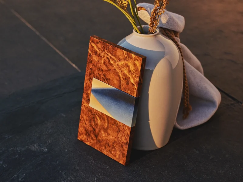 Dettaglio ravvicinato di smalto ceramico, venatura del legno e trama del lino